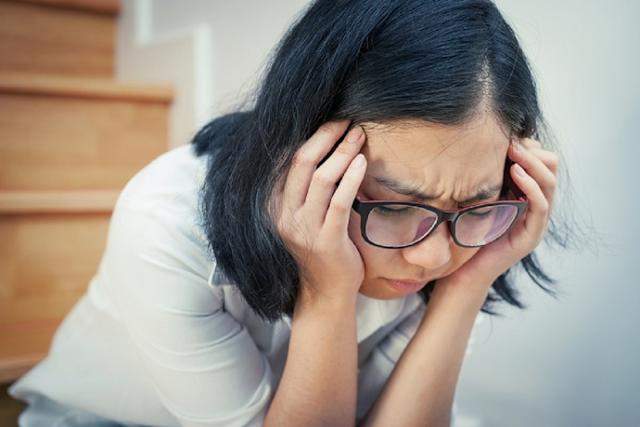 一位表現出明顯心理壓力與焦慮狀態的女性，象徵長期高皮質醇水平如何從生理層面影響重訓愛好者的恢復能力與肌肉合成效率。